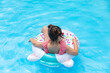 © Irina Mikhailichenko - Little girl having fun on vacation at the hotel pool. Colorful vacation concept. Summer outdoor activity during family vacation in tropical resort. Beach and water toys. Sun protection.