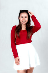 Wall Mural - Beautiful young Asian woman wearing a red long t-shirt and white skirt is posing