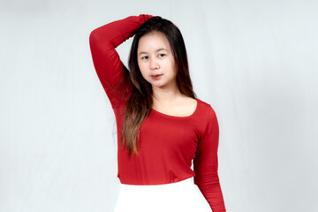 Wall Mural - Beautiful young Asian woman wearing a red long t-shirt and white skirt is posing
