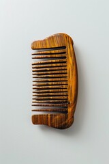 Wall Mural - Close-up of a wooden comb placed on a white surface, suitable for use in product photography or still life compositions