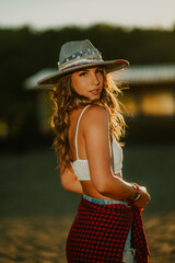 Wall Mural - Portrait of cowgirl standing at homestead and looking over her shoulder