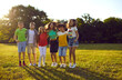 © Studio Romantic - Cheerful little kids teenagers from elementary school have fun together in nature and get ready to jump at same time during children outdoor party standing on lawn sunny park. Happy childhood concept