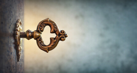 Fototapete - An old key in a keyhole on the background of an ancient manuscript, macro photography. The key to knowledge. Concept and idea for history, education, business, security, secret background.
