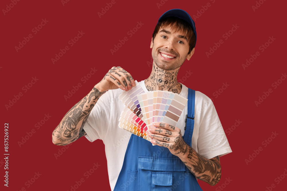 Male painter with palette samples on color background