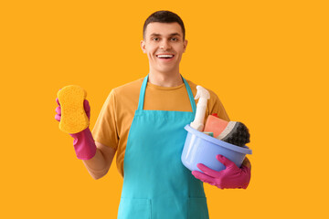 Sticker - Young man with cleaning  supplies on yellow  background