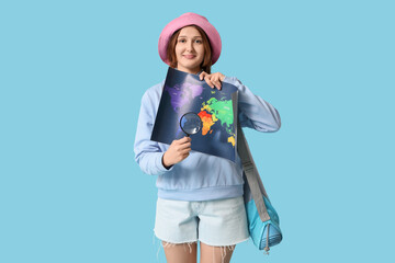 Poster - Young woman showing map with  magnifying glass on blue background. Travel concept