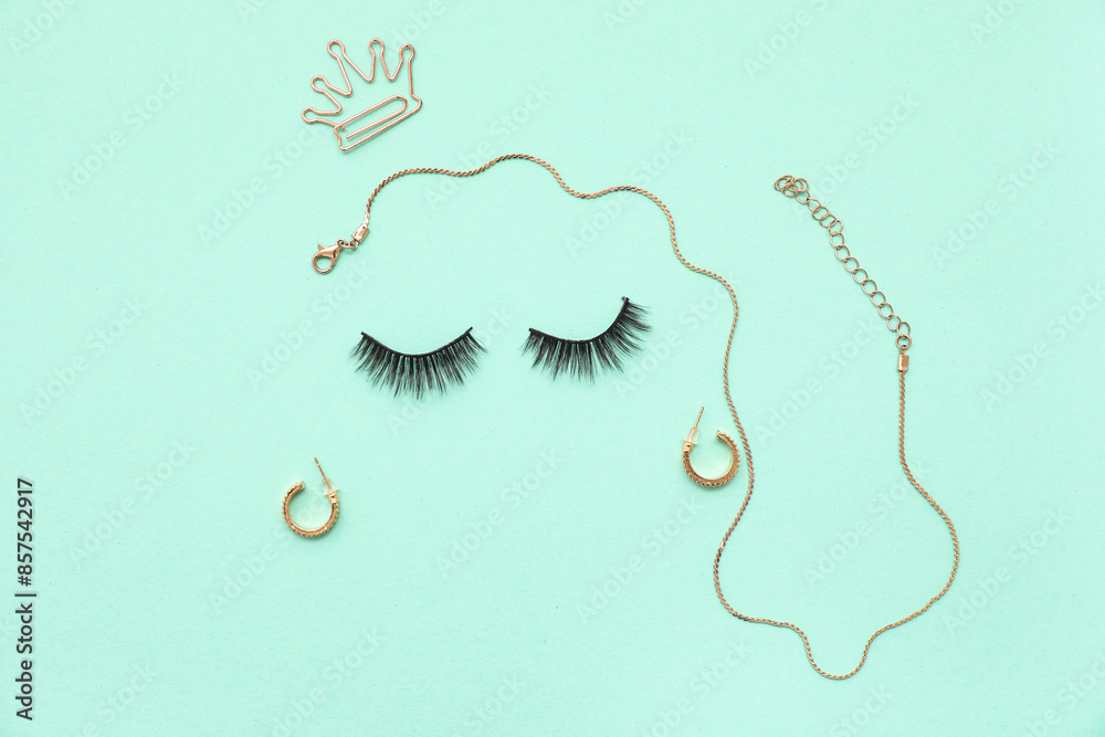 Creative composition with false eyelashes and jewelry on turquoise background