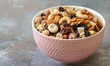 © TheoTheWizard - Mixed nut and dried fruit trail mix in a pastel pink bowl