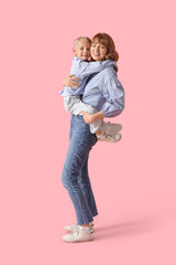 Poster - Happy mother and her little son hugging on pink background