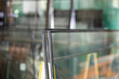 © JackF - Close-up of insulated glass units stacked on support stand in workshop, with various glass panels and industrial equipment in blurred background