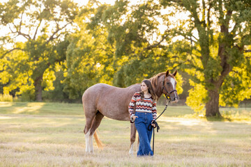 Wall Mural - Young equestrian girl woman with horse pony casual clothes