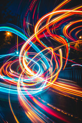 Wall Mural - Long-exposure light trails in different colors forming dynamic patterns, symbolizing the movement and flow of ideas. 