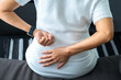 © Photo Sesaon - woman's hand he is caught at the waist and her back is painful at the back in the room. health concept