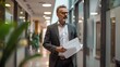 © Khoirul - Middle-aged businessman carrying document paper, company boss wearing white shirt and black suit, walking proudly in the office.