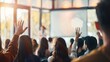 © ASHFAQ - A woman is raising hand up while businessman is speaking in training at the office.