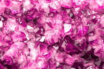 Amethyst pink crystals. Gems. Mineral crystals in the natural environment. Texture of precious and semiprecious stones. Seamless background with copy space colored shiny surface of precious stones.