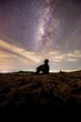 © STOCK PHOTO 4 U - Silhouette of Person Sitting Under Starry Night Sky with Milky Way Galaxy in Background