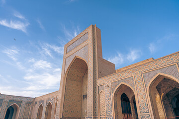 The building is old and has a lot of arches. The sky is blue and there are clouds in the background