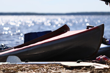 Poster - Row of canoes parked on the shore of a lake, suitable for use in outdoor recreation or travel images