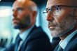 © Renata Hamuda - close up of Focused executive with glasses listening at meeting in a conference room