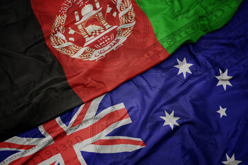 Wall Mural - waving colorful flag of afghanistan and national flag of australia on the dollar money background. finance concept.