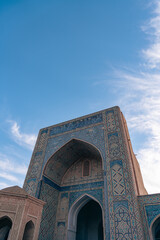 Wall Mural - The blue and white building has a large archway. The sky is clear and blue. The building is old and has a lot of detail