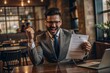 © N7 - Happy Businessman Holding Signed Contract - Businessman celebrating with a signed contract in hand.