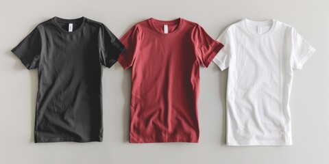 Wall Mural - Three t-shirts are displayed on a table, with one black, one red, and one white