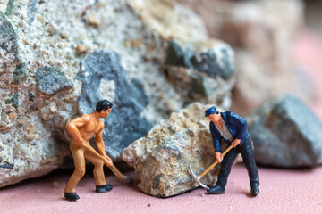 Wall Mural - A miniature worker worker drilling a big rock . Themes of perseverance, strength and labor.