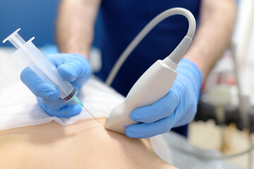 Mammalogist doctor examines woman breasts and lymph nodes during appointment. Skillful oncologist puncture of mammary glands of young patient under review ultrasound for diagnosis of breast cancer