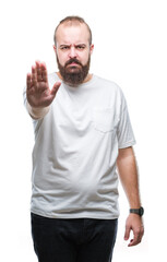 Sticker - Young caucasian hipster man wearing casual t-shirt over isolated background doing stop sing with palm of the hand. Warning expression with negative and serious gesture on the face.