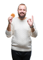 Sticker - Young caucasian hipster man eating sweet waffle over isolated background doing ok sign with fingers, excellent symbol