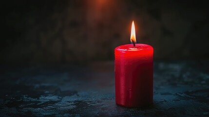 Wall Mural - Red candle casting dim light in dark with copy space