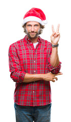 Wall Mural - Handsome hispanic man model wearing santa claus christmas over isolated background smiling with happy face winking at the camera doing victory sign. Number two.