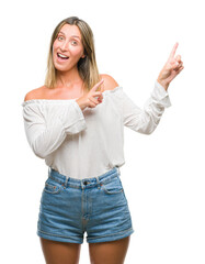 Young beautiful woman over isolated background smiling and looking at the camera pointing with two hands and fingers to the side.