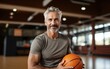 © imagineRbc - A man with a basketball in his hand is smiling. He is in a gym. Scene is happy and energetic