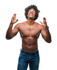 Wall Mural - Afro american shirtless man showing nude body over isolated background smiling crossing fingers with hope and eyes closed. Luck and superstitious concept.