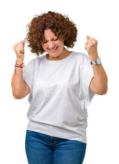 Poster - Beautiful middle ager senior woman wearing white t-shirt over isolated background very happy and excited doing winner gesture with arms raised, smiling and screaming for success. Celebration concept.