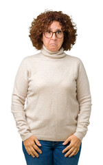 Canvas Print - Beautiful middle ager senior woman wearing turtleneck sweater and glasses over isolated background depressed and worry for distress, crying angry and afraid. Sad expression.