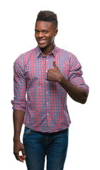 Canvas Print - Young african american man over isolated background doing happy thumbs up gesture with hand. Approving expression looking at the camera with showing success.