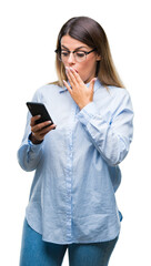 Wall Mural - Young beautiful business woman texting message using smartphone over isolated background cover mouth with hand shocked with shame for mistake, expression of fear, scared in silence, secret concept