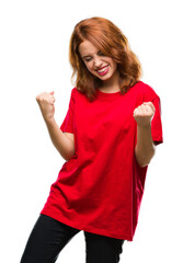 Canvas Print - Young beautiful woman over isolated background very happy and excited doing winner gesture with arms raised, smiling and screaming for success. Celebration concept.