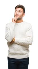 Wall Mural - Young handsome man wearing winter sweater over isolated background with hand on chin thinking about question, pensive expression. Smiling with thoughtful face. Doubt concept.