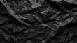 © wanchai - A black paper with a crumpled texture. The paper is torn and has a rough texture