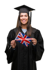 Poster - Young hispanic woman wearing graduated uniform holding flag of united kingdom with a happy face standing and smiling with a confident smile showing teeth