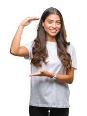 Wall Mural - Young beautiful arab woman over isolated background gesturing with hands showing big and large size sign, measure symbol. Smiling looking at the camera. Measuring concept.