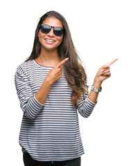 Canvas Print - Young beautiful arab woman wearing sunglasses over isolated background smiling and looking at the camera pointing with two hands and fingers to the side.