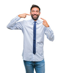 Poster - Adult hispanic business man over isolated background smiling confident showing and pointing with fingers teeth and mouth. Health concept.