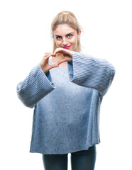 Sticker - Young beautiful blonde and blue eyes woman wearing winter sweater over isolated background smiling in love showing heart symbol and shape with hands. Romantic concept.