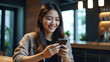 © New generate - Smiling young asian woman using mobile phone and credit card for mobile banking, digital payment via mobile app.